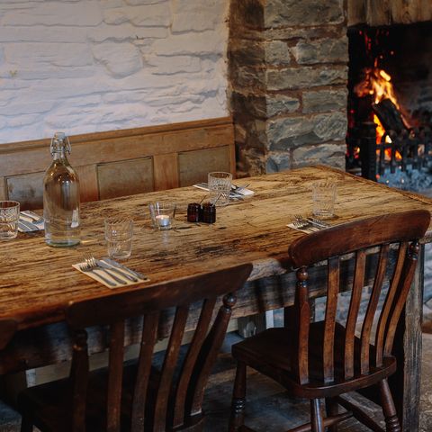 table in pub by an open roaring fire