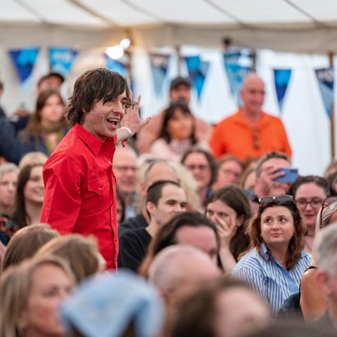 A presenter in a crowd at a festival
