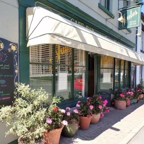 Outdoor view of small restaurant with pot plants and canopy 