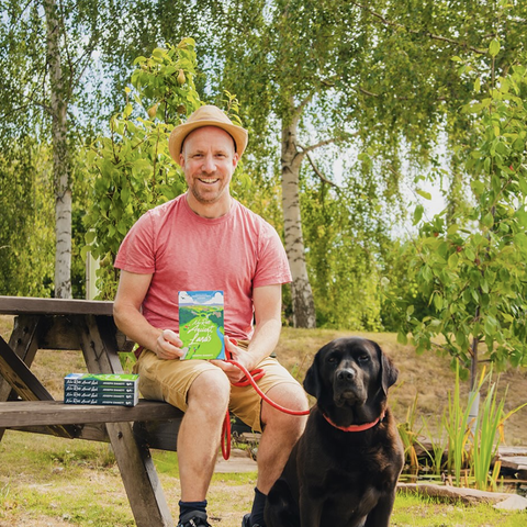 Author Joe Emmet in a garden with his dog