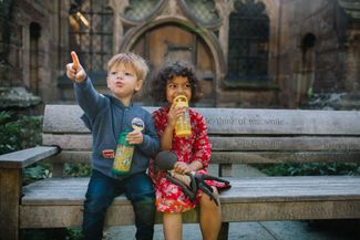 two children sitting on a bench outside