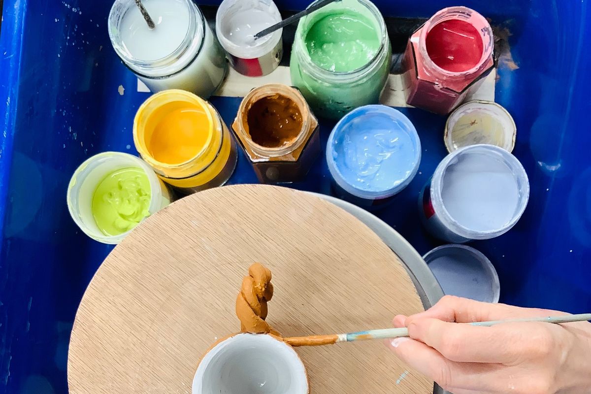 Turned clay pots being glazed