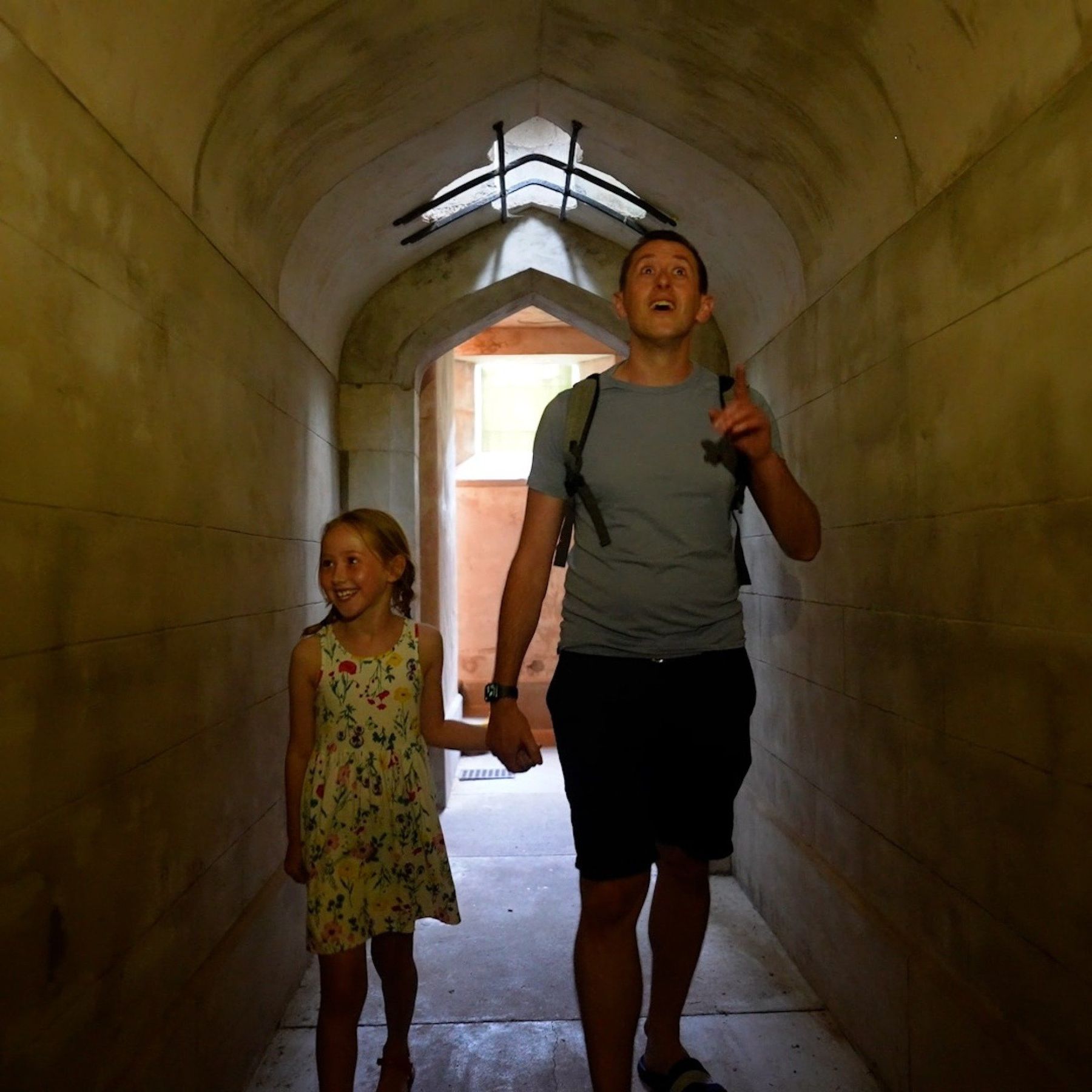 Father and daughter in the secret tunnel looking up at the tunnel ceiling in wonder