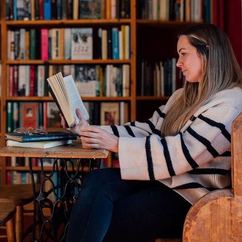 Girl reads a book at a table in Hereford
