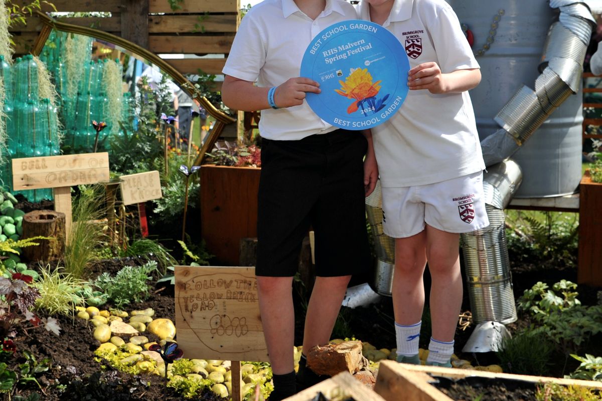 Children with a certificate in a garden at the RHS Malvern Spring show 