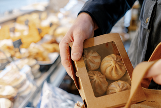 Putting mini pork pies in a shopping bag