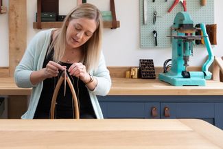 woman making hand made leather goods