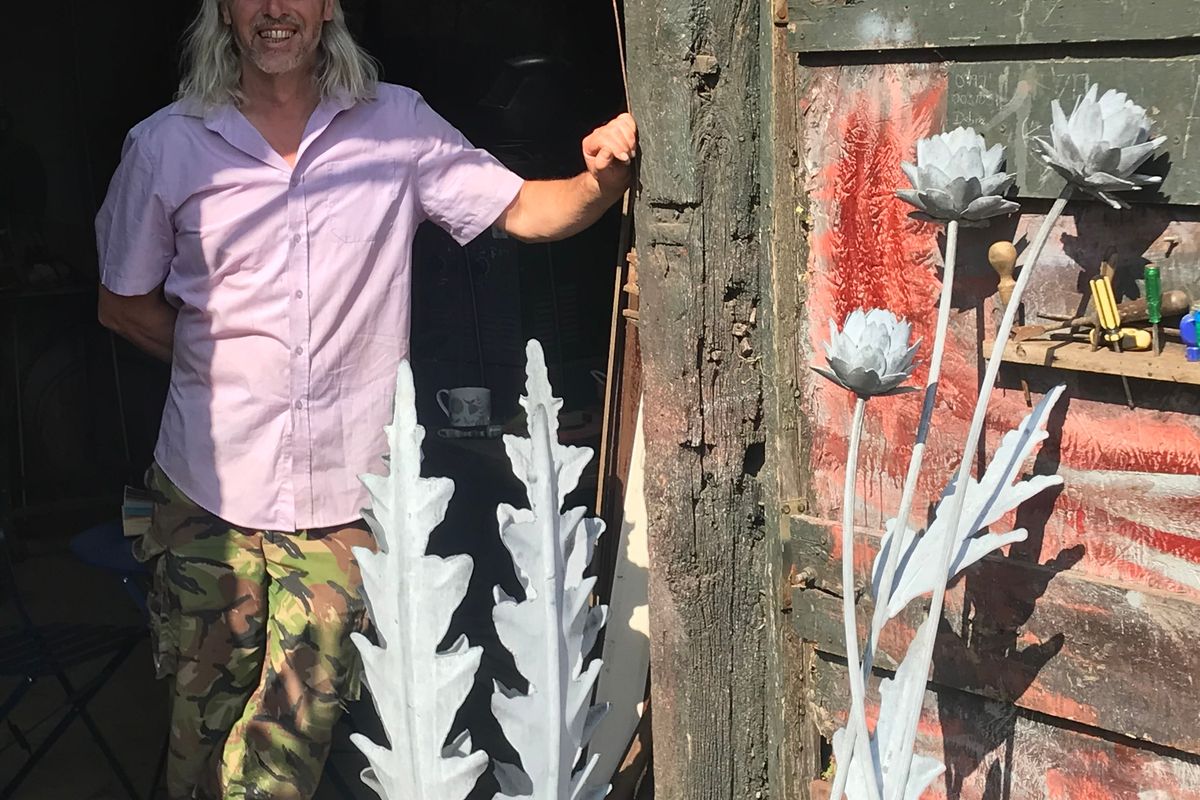 man with pewter sculptures in organic long leaf-like designs