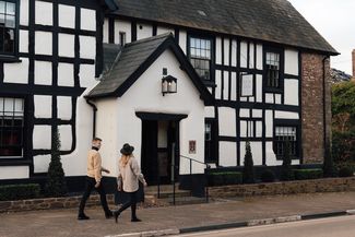 Young couple walking towards traditional black and white pub