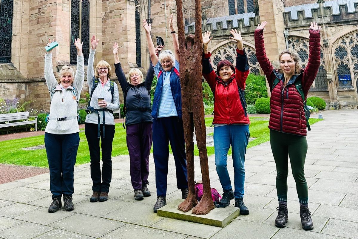 Women pilgrims with arms in the air at Hereford cathedral
