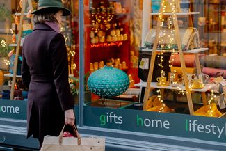 Woman looking through Christmassy shop window