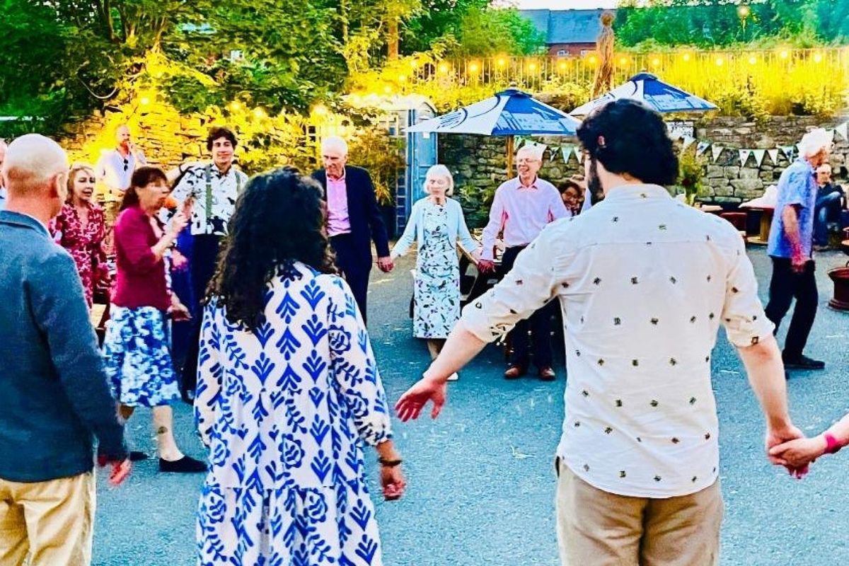 Ceilidh dancers stand in a circle