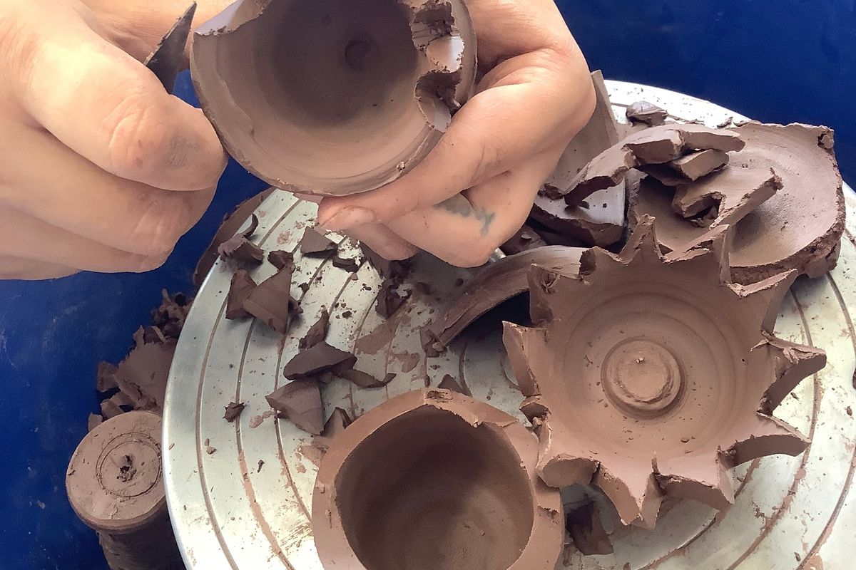 turned clay pots being carved with tools