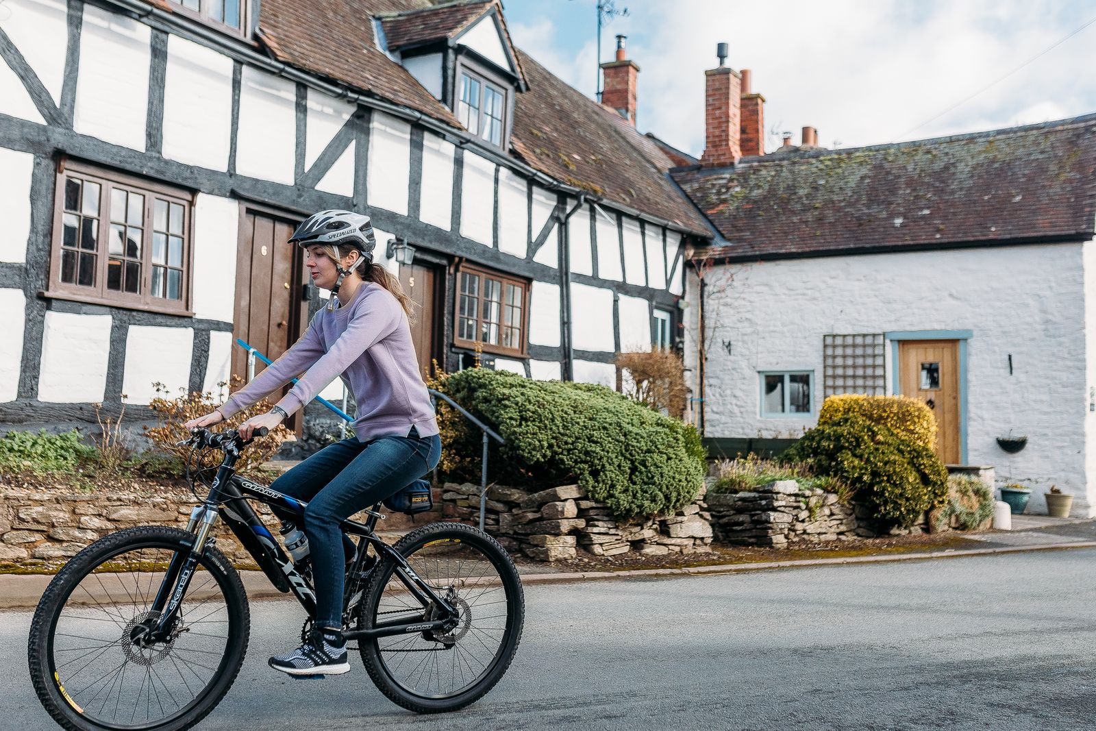 woman cycling through black and white village