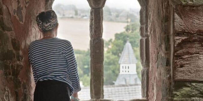 Woman looks out over hay castle during herefordshire histories festival