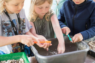 Children taking place at an archeological dig