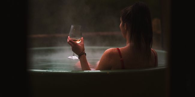 Woman holding a glass of wine in a hot tub
