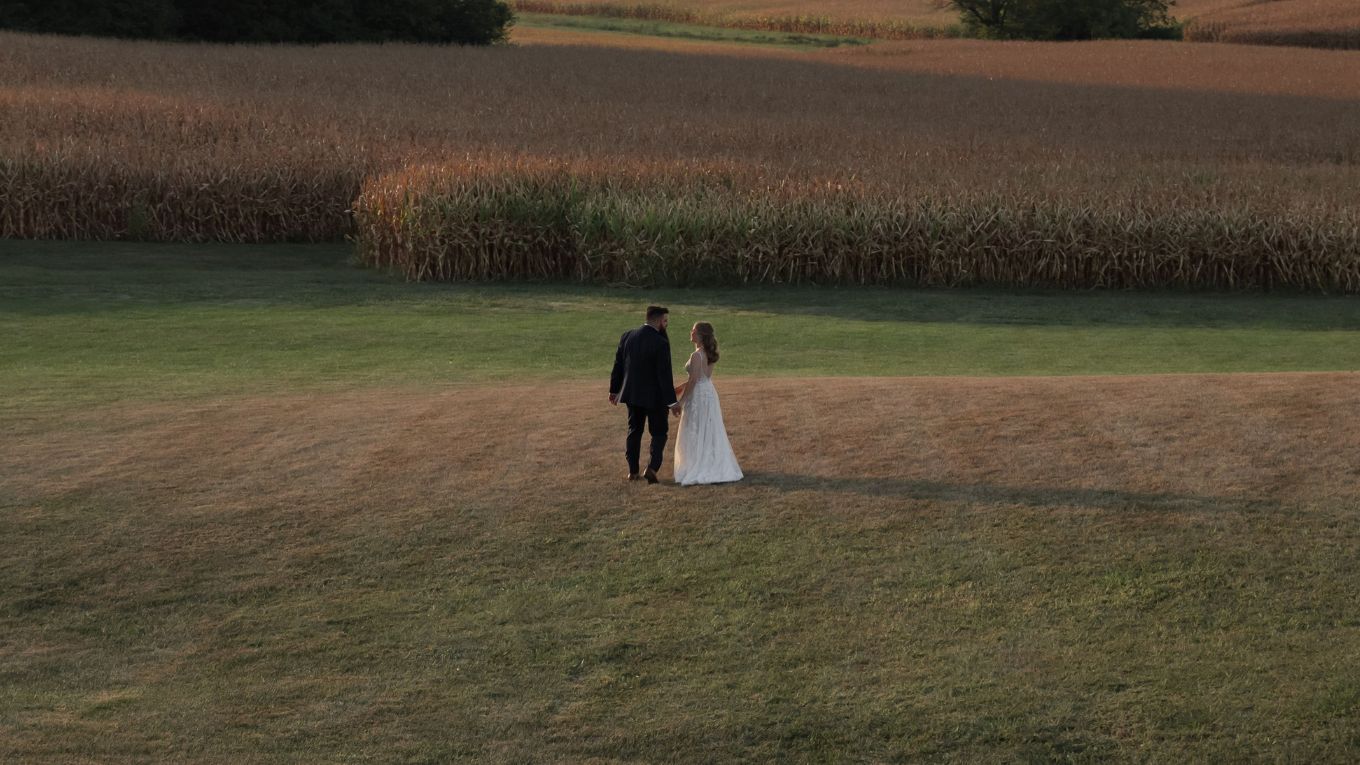 bride and groom standing in a field 
