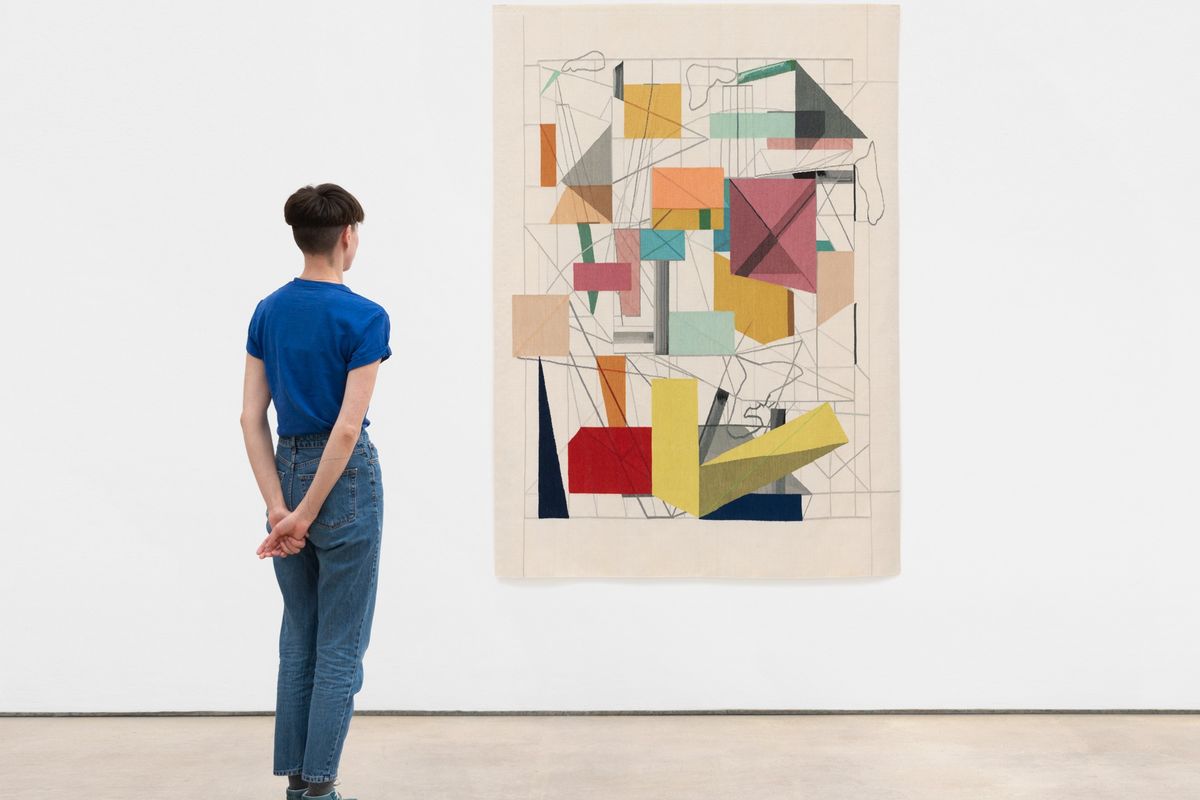 Man stood in front of abstract artwork on white wall