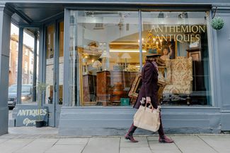 Woman walking past antique shop