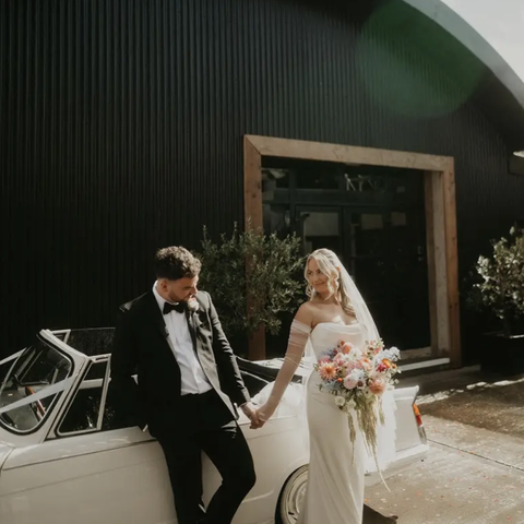 Bridge and groom against a white car