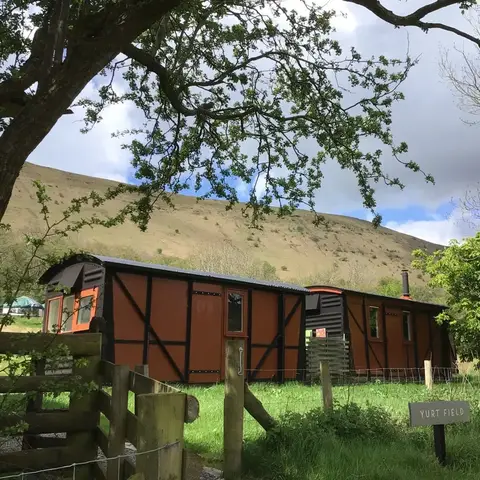 cabins nestled in a field within a deep valley