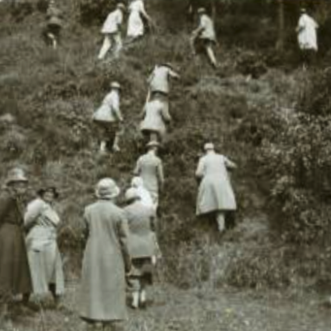 Old photograph showing members of the old straight club climbing a steep mound
