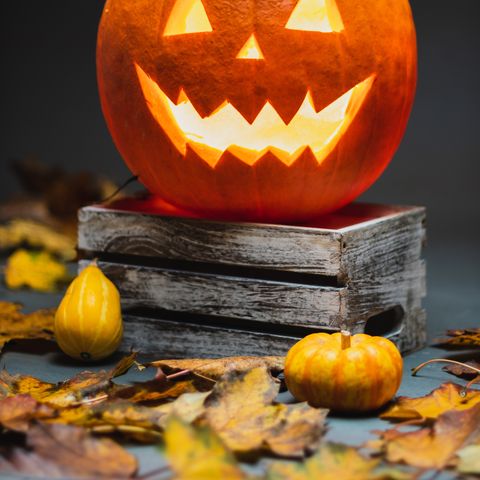 Pumpkin spookily carved on top of books