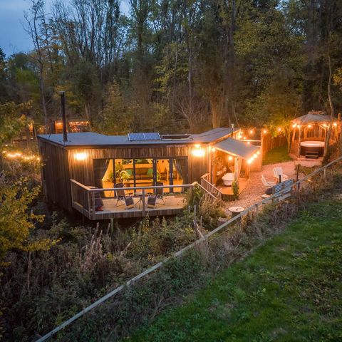 A sprawling treehouse cabin lit up by fairy lights