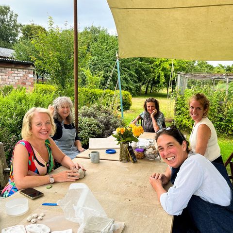 A group of people around a table at a pottery class 