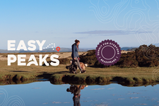 Photo of person walking on a hilltop waterscape with 'Easy Peaks' logo overlaid