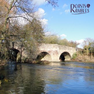 river flowing through bridge with blue sky above