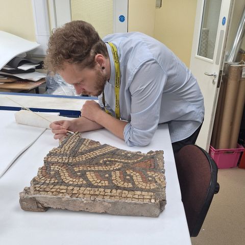 A person restoring a mosaic