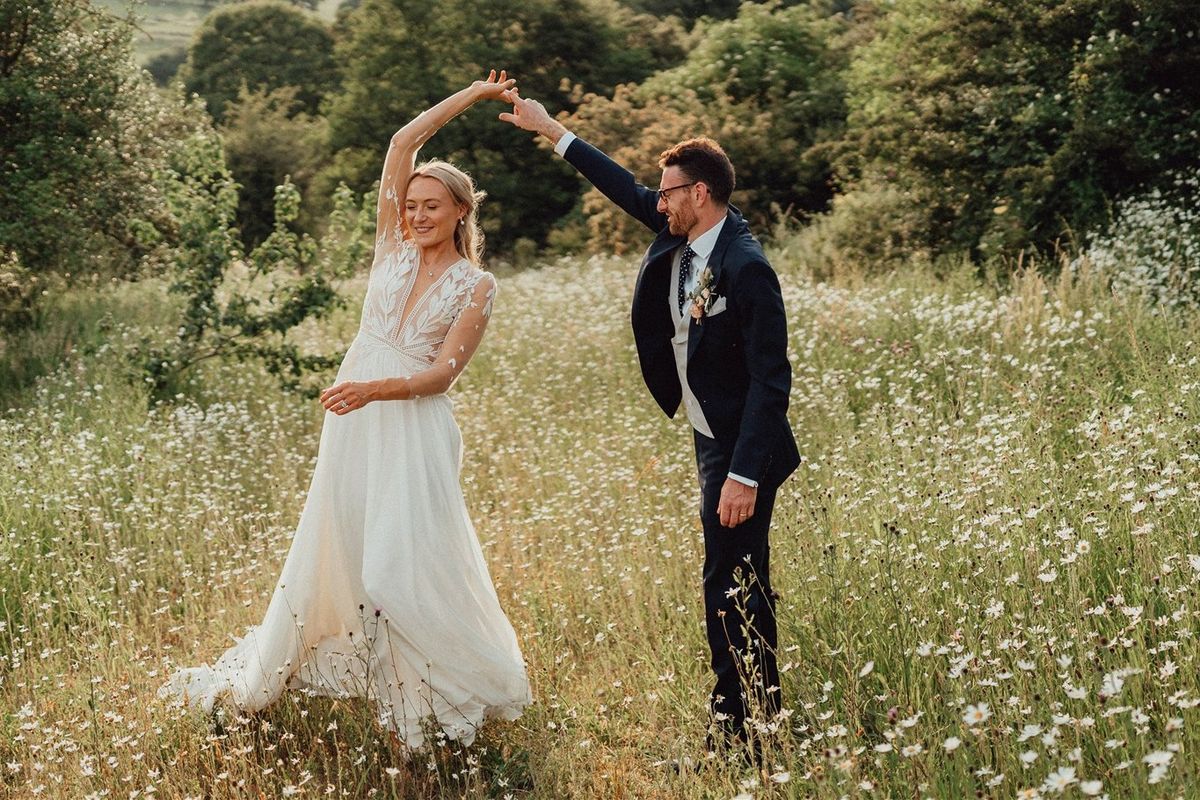 a bride and groom in a meadow