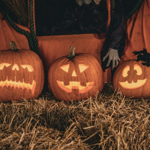 pumpkins carved and resting on straw