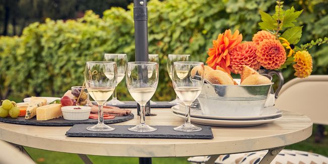 Flight of Wine Glasses with cheeseboard next to vineyard