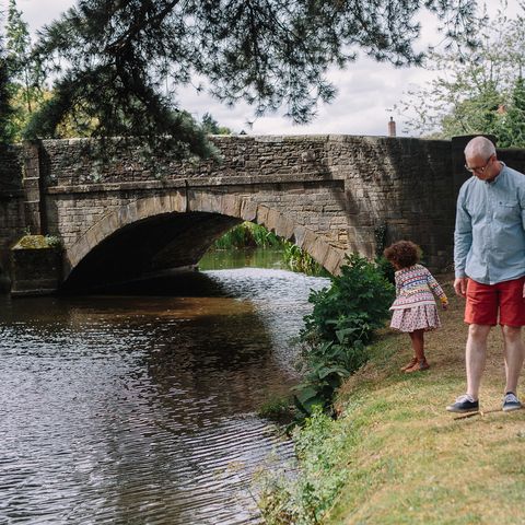 Father and daughter by river in Eardisland