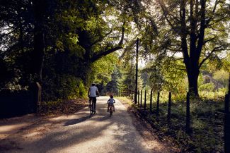 A parent and child cycle down a lane