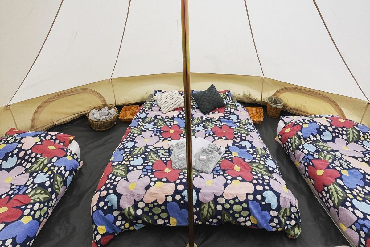 Inside bell tent with three beds