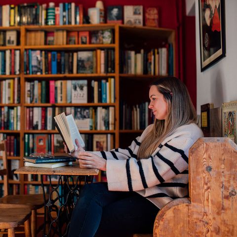 Woman reading sat down in bookshop cafe