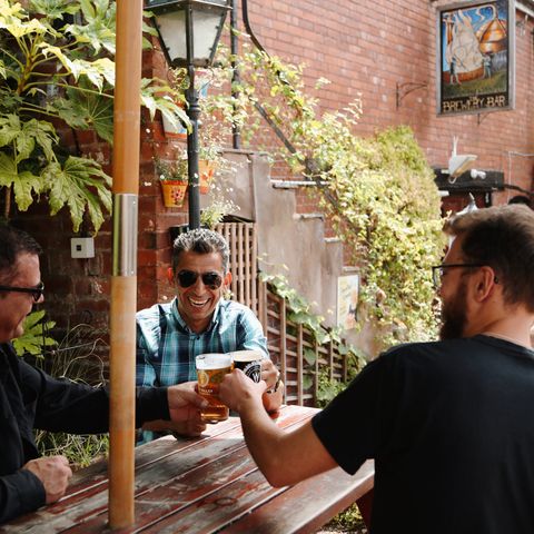 Men toast a pint at the barrels in hereford