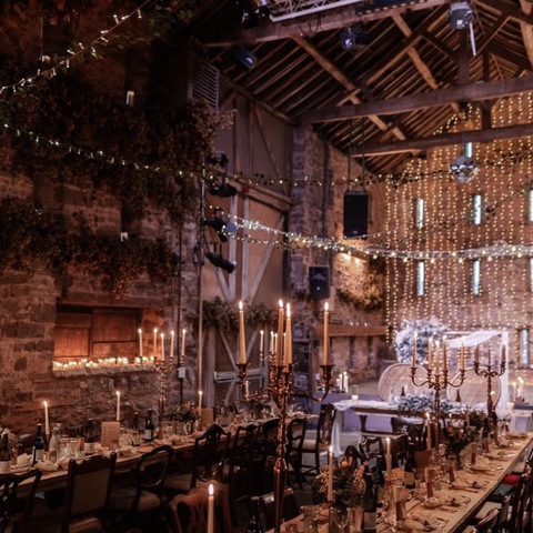Barn with long dining tables and twinkly lights
