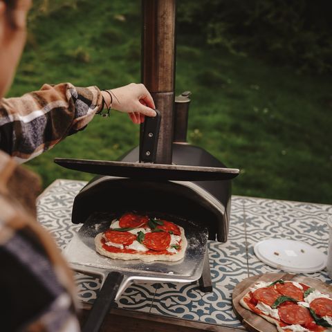 making a pizza in the outdoor pizza oven