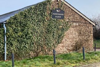 View of a building on Townsend Farm, enveloped with a climbing plant