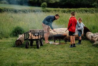 Family gathered near a firepit 