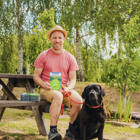 Joe emmet author and his black lab sitting in the garden 