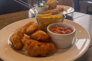 Kids chicken nuggets, chips and beans on a plate in a restaurant 