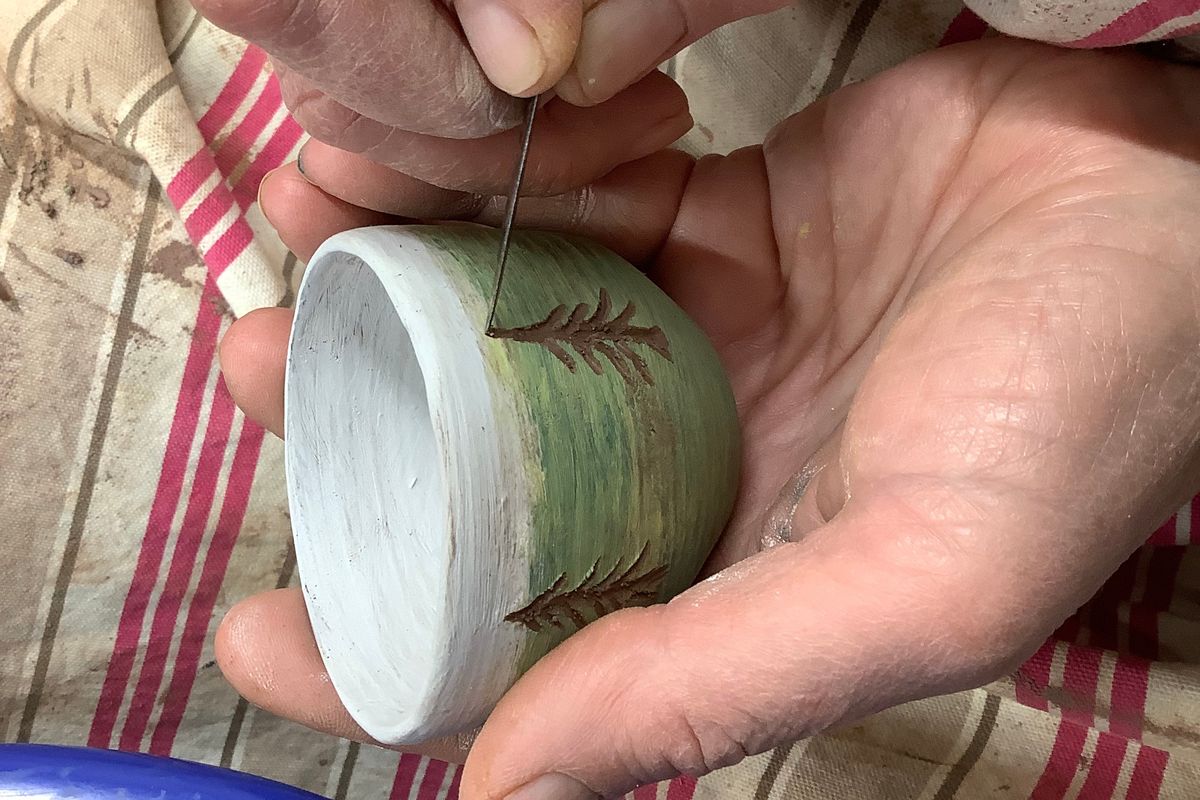 Turned pots being decorated before firing