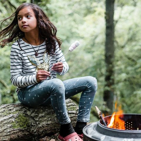 Girl roasts marshmallows in woodland