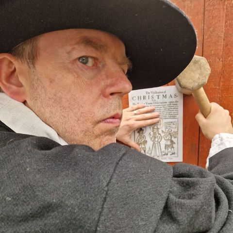 Puritan man putting up poster to say Christmas is banned